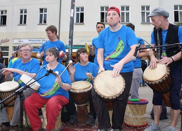 Trommelgruppe spielt gemeinsam auf einer Straße.
