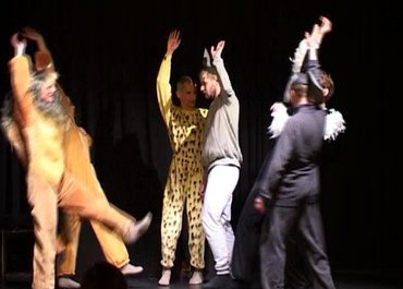 Darsteller in Tierkostümen heben die Arme in die Höhe.