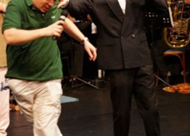 Zwei Personen stehen gemeinsam am Mikrofon.